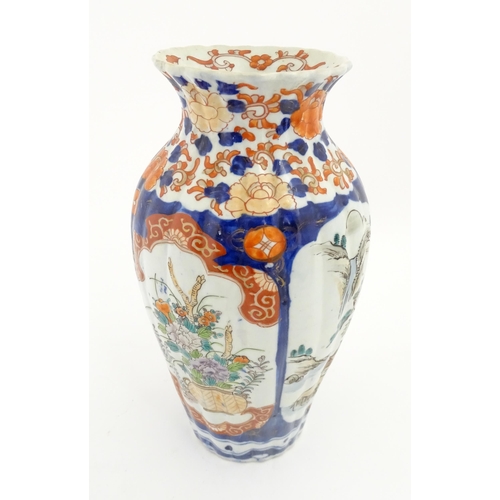 72A - A Japanese vase of lobed form in the Imari palette decorated with flowers and foliage, and landscape... 