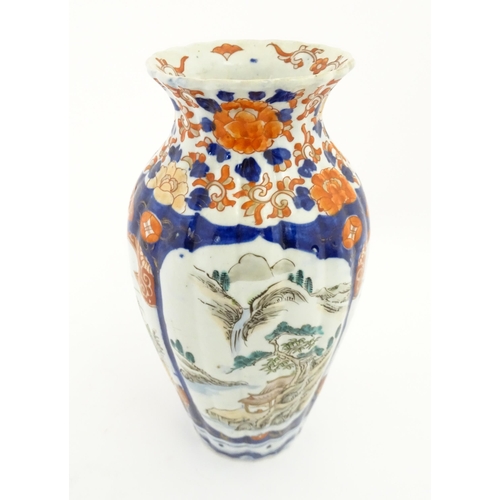 72A - A Japanese vase of lobed form in the Imari palette decorated with flowers and foliage, and landscape... 