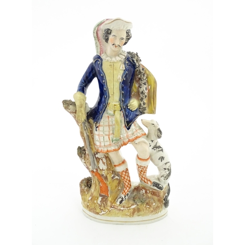 79 - A Staffordshire pottery figure depicting a Scottish hunter with his dog and rifle. Approx. 14