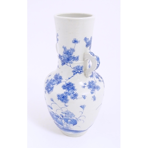 8 - A Japanese blue and white twin handled vase with hand painted decoration depicting birds, flowers an... 