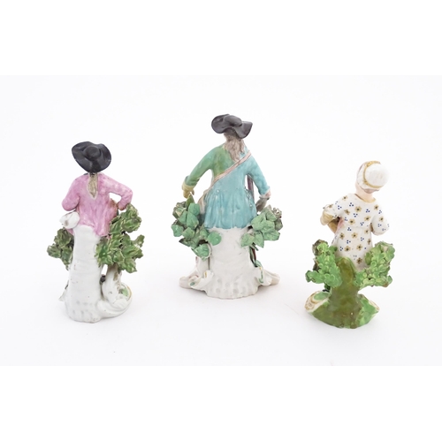 85 - Three ceramic figures comprising a Derby style model of a child holding a basket of flowers, a seate... 