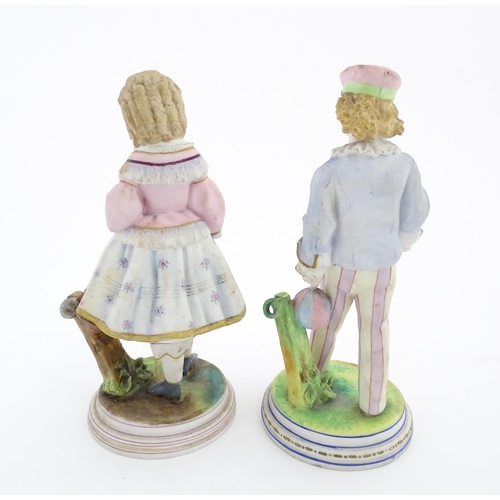 90 - A pair of bisque figures comprising a sailor boy and a girl with a floral dress. Approx. 9 1/4