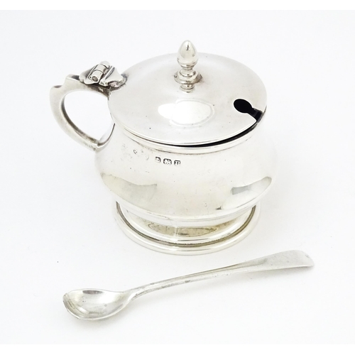 568 - A silver mustard pot with blue glass liner hallmarked Birmingham 1944. With associated silver spoon.... 