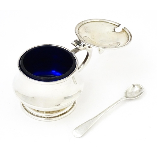 568 - A silver mustard pot with blue glass liner hallmarked Birmingham 1944. With associated silver spoon.... 