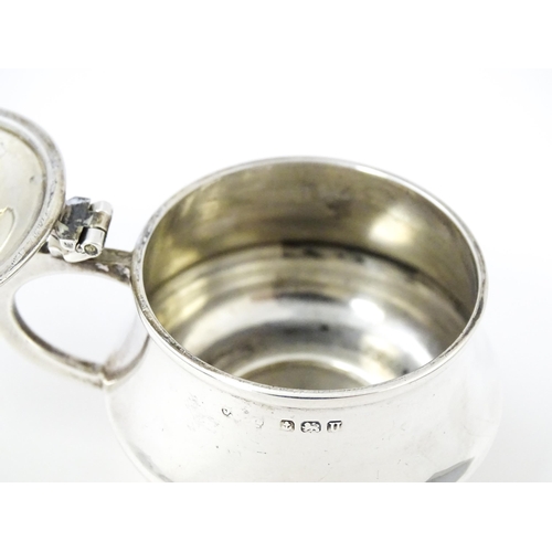 568 - A silver mustard pot with blue glass liner hallmarked Birmingham 1944. With associated silver spoon.... 