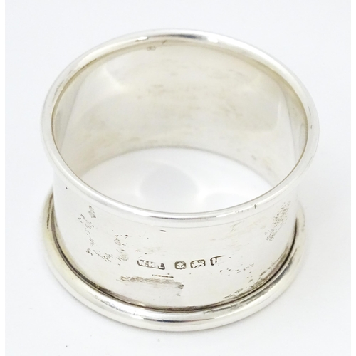 577 - A silver napkin ring hallmarked Birmingham 1919, maker William Henry Leather. Together with a silver... 