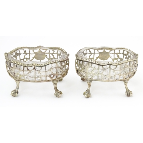 586 - A pair of Geo III silver salts with openwork decoration and raised on ball and claw feet, with clear... 