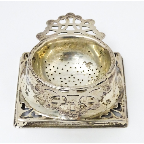 587 - A silver strainer and stand with pierced decoration hallmarked Birmingham 1944, maker Thomas Bishton... 