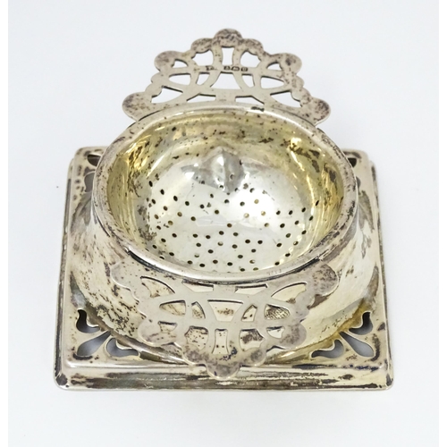 587 - A silver strainer and stand with pierced decoration hallmarked Birmingham 1944, maker Thomas Bishton... 