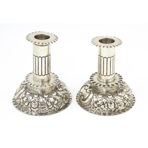 591 - A pair of Victorian candlesticks with embossed decoration, hallmarked London 1886, maker Charles Stu... 