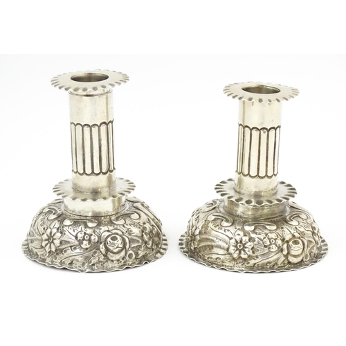 591 - A pair of Victorian candlesticks with embossed decoration, hallmarked London 1886, maker Charles Stu... 