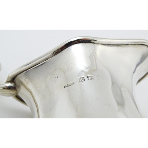 601 - An Art Nouveau silver cream jug hallmarked Birmingham 1908, maker E. S Barnsley & Co. Approx. 4 1/4