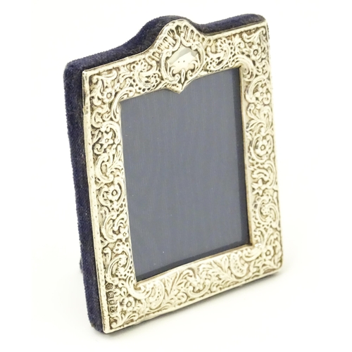 607 - An easel back photograph frame with embossed silver surround hallmarked London 1997, maker Kitney & ... 