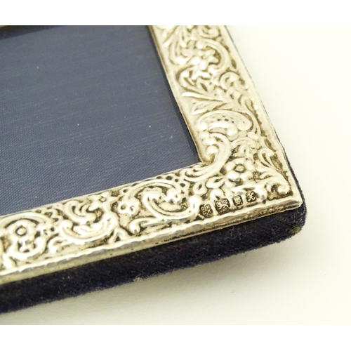 607 - An easel back photograph frame with embossed silver surround hallmarked London 1997, maker Kitney & ... 