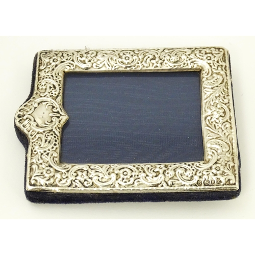 607 - An easel back photograph frame with embossed silver surround hallmarked London 1997, maker Kitney & ... 