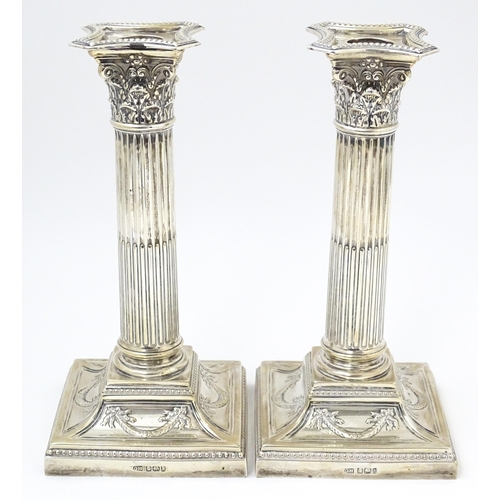 650 - A pair of silver candlesticks of Corinthian column form hallmarked Sheffield 1902, maker Harrison Br... 