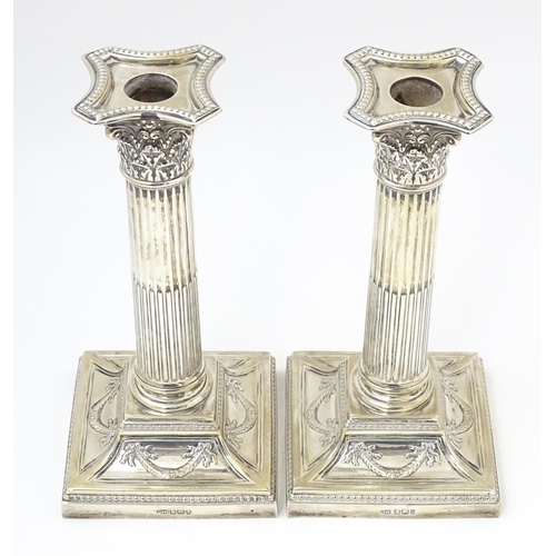 650 - A pair of silver candlesticks of Corinthian column form hallmarked Sheffield 1902, maker Harrison Br... 