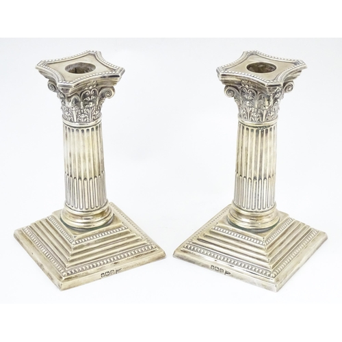 657 - A pair silver candlesticks of Corinthian column form with squared stepped bases, hallmarked Sheffiel... 