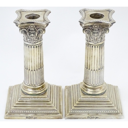 657 - A pair silver candlesticks of Corinthian column form with squared stepped bases, hallmarked Sheffiel... 