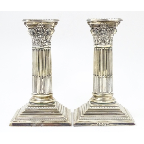 657 - A pair silver candlesticks of Corinthian column form with squared stepped bases, hallmarked Sheffiel... 