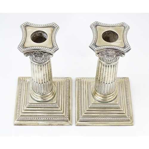 657 - A pair silver candlesticks of Corinthian column form with squared stepped bases, hallmarked Sheffiel... 