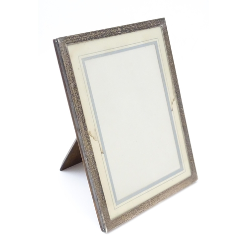 662 - An easel back photograph frame with silver surround, hallmarked Birmingham 1929. Approx. 8 3/4