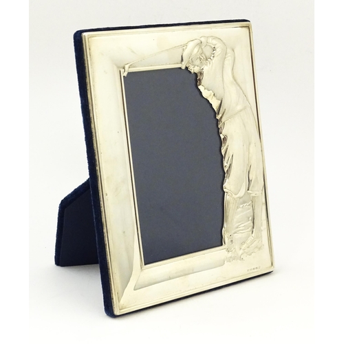 665 - An easel back photograph frame with silver surround with golfer detail, hallmarked Sheffield 2003, m... 