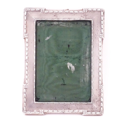 666 - A photograph frame with silver surround with engine turned decoration, hallmarked Sheffield 1913, ma... 