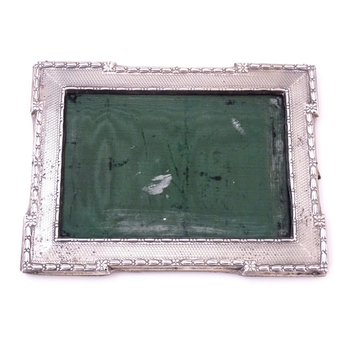 666 - A photograph frame with silver surround with engine turned decoration, hallmarked Sheffield 1913, ma... 