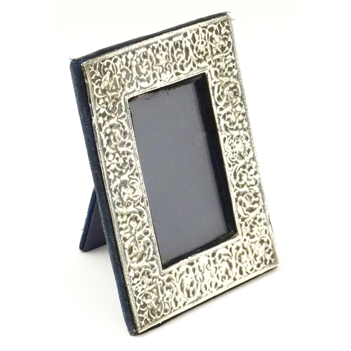 668 - An easel back photograph frame with embossed silver surround, hallmarked London 1983, maker Samuel I... 