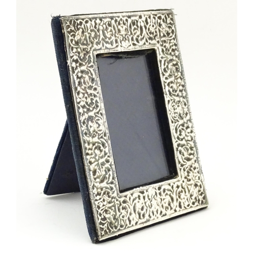 668 - An easel back photograph frame with embossed silver surround, hallmarked London 1983, maker Samuel I... 