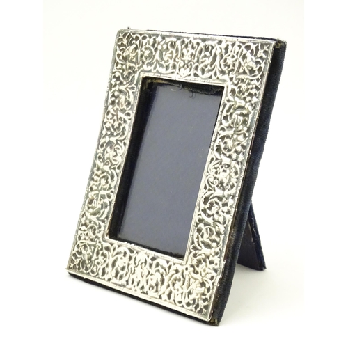 668 - An easel back photograph frame with embossed silver surround, hallmarked London 1983, maker Samuel I... 