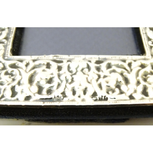 668 - An easel back photograph frame with embossed silver surround, hallmarked London 1983, maker Samuel I... 