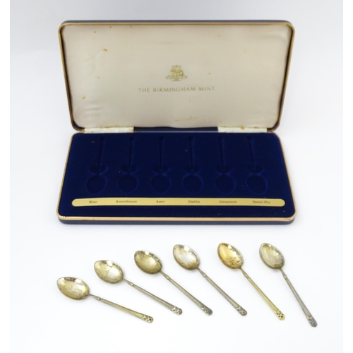 670 - A cased set of six silver gilt teaspoons, the bowl backs with enamel decoration depicting various fl... 