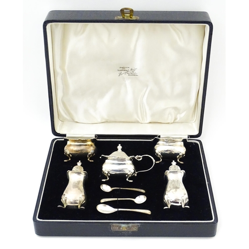 671 - A silver five piece cruet set comprising two salts, two peppers, a mustard pot, and spoons hallmarke... 