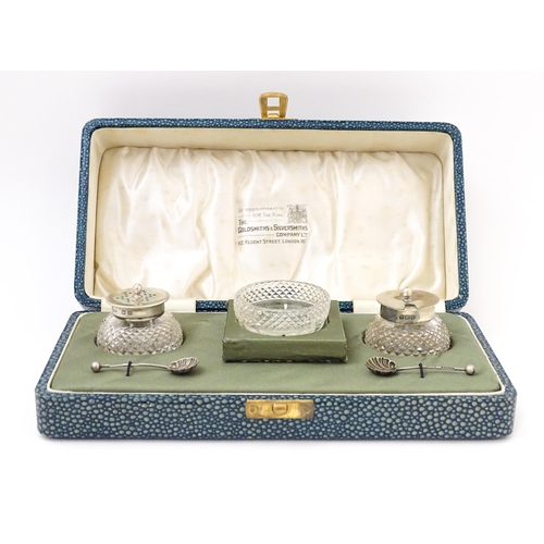 672 - A silver and cut glass three piece cruet set comprising salt, pepper and mustard, hallmarked Birming... 