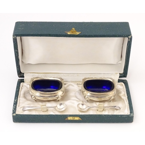 674 - A cased pair of silver salts with blue glass liners, hallmarked London 1910, maker Reid & Sons. With... 