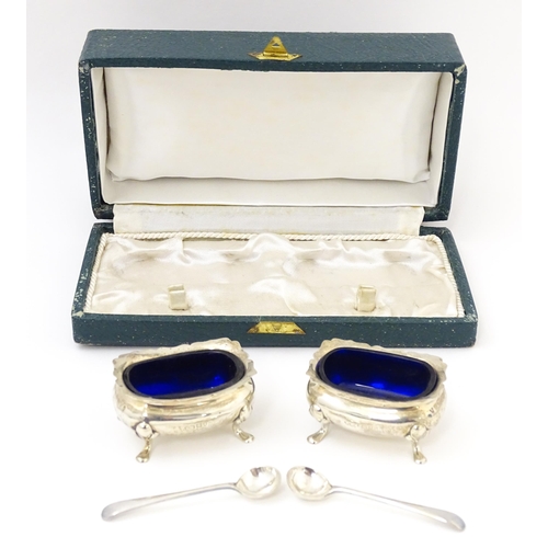 674 - A cased pair of silver salts with blue glass liners, hallmarked London 1910, maker Reid & Sons. With... 