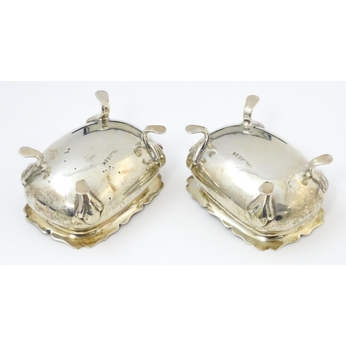 674 - A cased pair of silver salts with blue glass liners, hallmarked London 1910, maker Reid & Sons. With... 