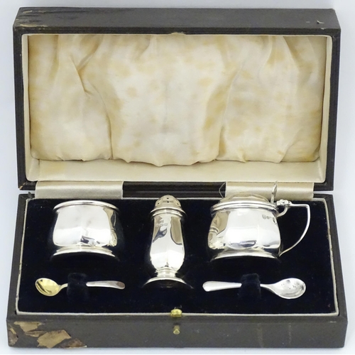 691 - A silver three piece cruet set comprising salt, pepper and mustard with blue glass liners, hallmarke... 