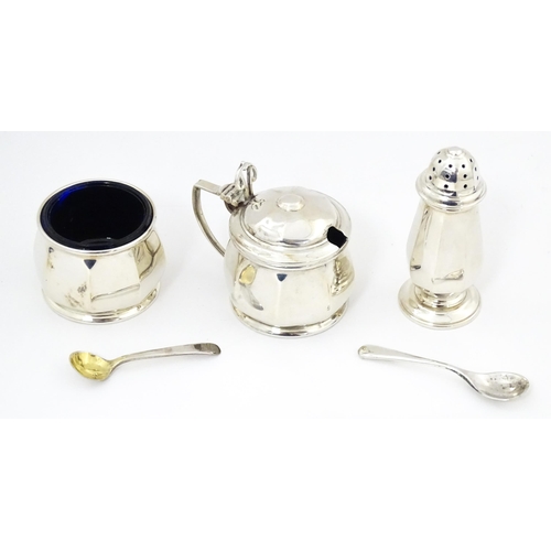 691 - A silver three piece cruet set comprising salt, pepper and mustard with blue glass liners, hallmarke... 