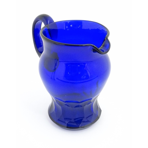 269 - A 19thC Blue glass jug with loop handle and banded facet cut detail. Approx 7 1/2