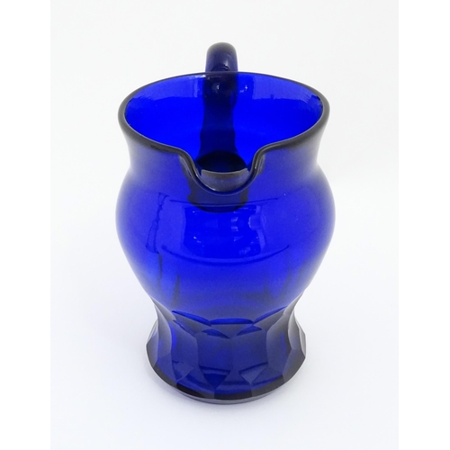 269 - A 19thC Blue glass jug with loop handle and banded facet cut detail. Approx 7 1/2