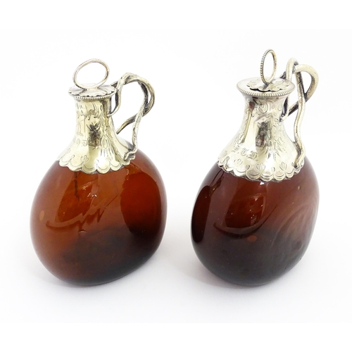 273 - Two Victorian whiskey flasks / spirit flagons, the brown amber glass bottles with silver plate mount... 