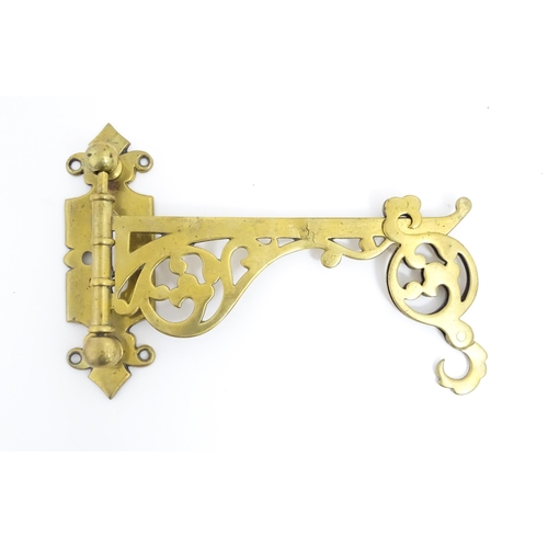 1186 - A late 19th / early 20thC brass firestick bracket with hook. Approx. 9 1/2