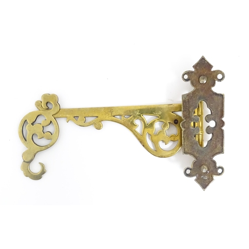 1186 - A late 19th / early 20thC brass firestick bracket with hook. Approx. 9 1/2