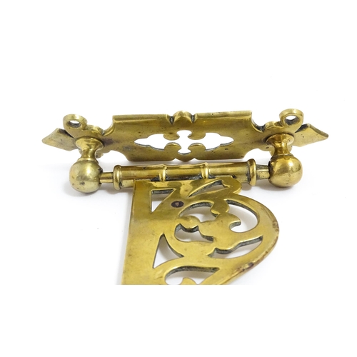 1186 - A late 19th / early 20thC brass firestick bracket with hook. Approx. 9 1/2