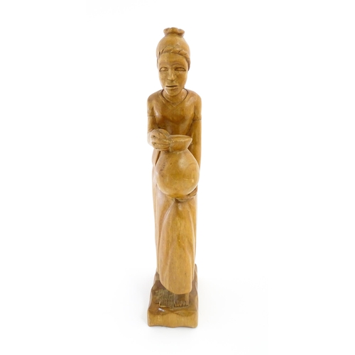 1193 - Ethnographic / Native / Tribal: An African carved wooden figure modelled as a female water carrier w... 