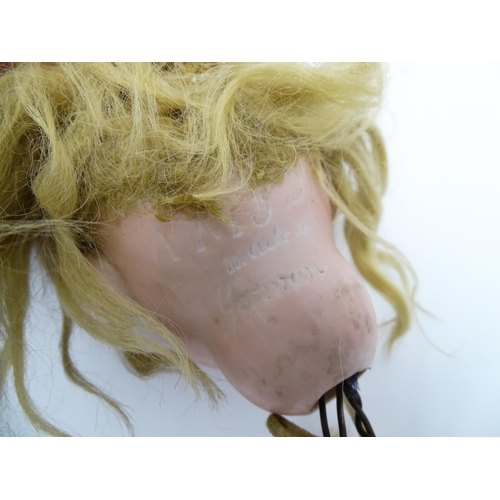 1433 - Toy: An Armand Marseille bisque doll head with painted features. Together with composite body and ar... 