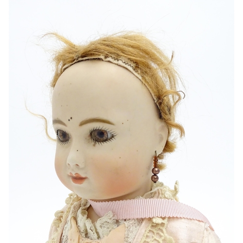 1434 - Toy: A 20thC porcelain doll with painted features and bead drop earrings. Approx. 16